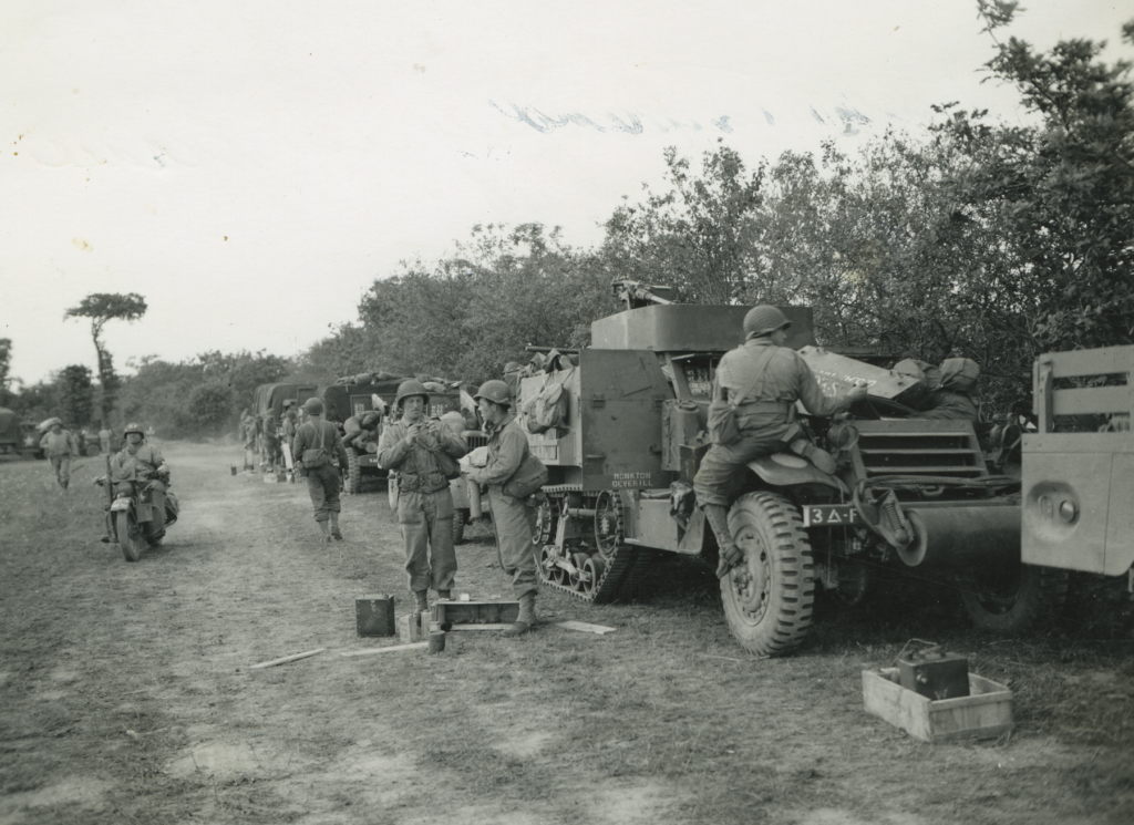 Photo of tank and soldiers along a dirt road